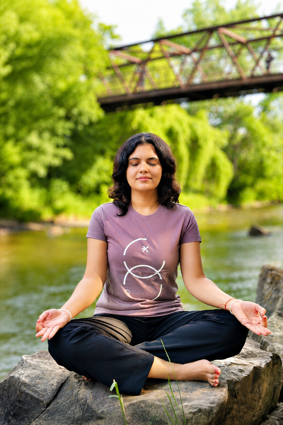 Tamanna Sharma seated outdoors in meditation beside a calm stream
